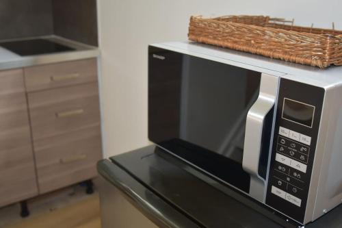 a microwave on a counter with a basket on top of it at Kibbelschuur in Zottegem