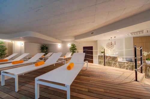 a room with white chairs on a wooden deck at Noru Hotel Malta - Adults Only Hotel in St Julian's