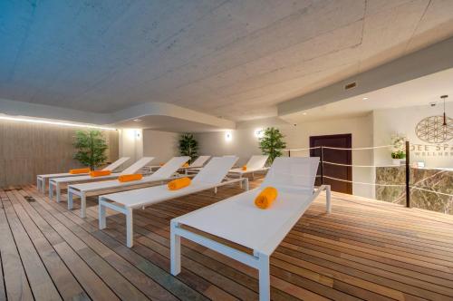 a room with white chairs and orange pillows at Noru Hotel Malta - Adults Only Hotel in St Julian's