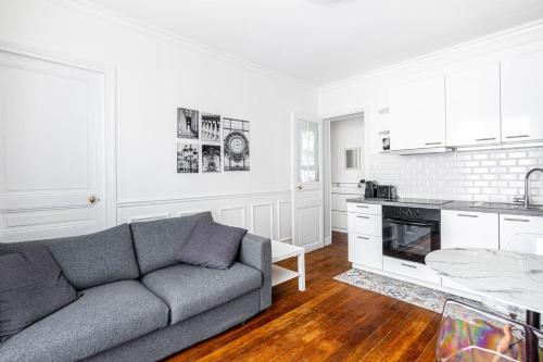 un salon avec un canapé et une cuisine dans l'établissement GuestReady - Apt. Cosy et confortable dans le 10e, à Paris