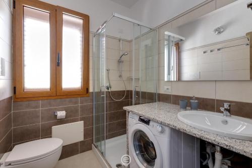 a bathroom with a washing machine and a sink at Lemon Apartment 2 in Àrbatax