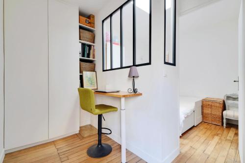 un bureau avec un bureau et une chaise verte dans l'établissement GuestReady - Modern Comfort near Montparnasse, à Paris