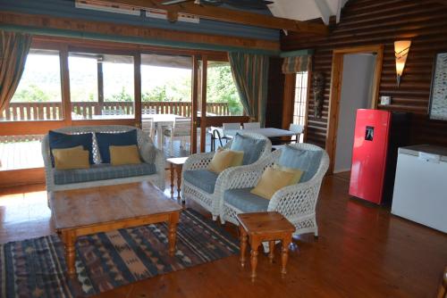 a living room with chairs and a table and a refrigerator at House 52 in Sodwana Bay