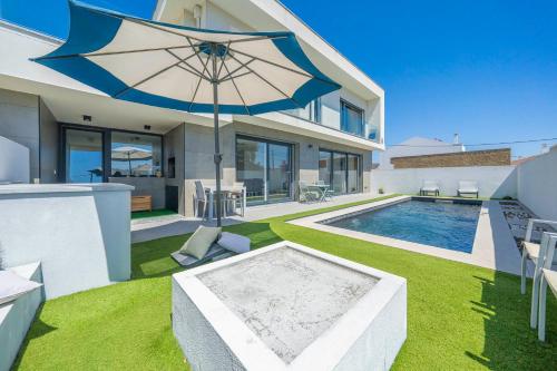a house with a swimming pool and an umbrella at Black Pool House just 10 minutes away from the beach in Amora