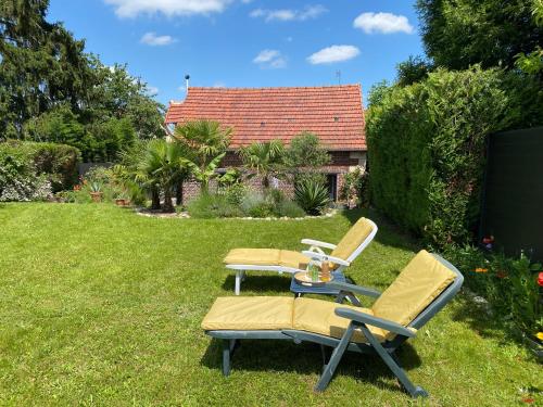 two chairs sitting on the grass in a yard at La Maison Angèle in Caisnes