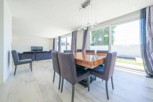 a dining room with a wooden table and chairs at Black Pool House just 10 minutes away from the beach in Amora