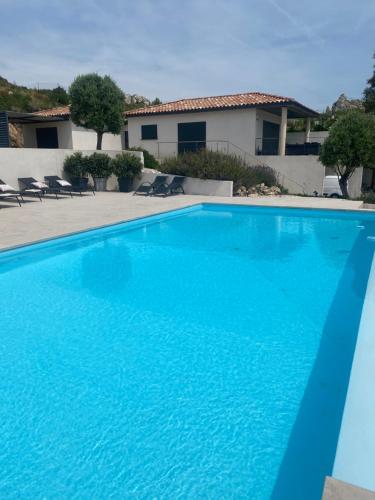a large blue swimming pool in front of a house at LOCRIZEN in Le Rouet