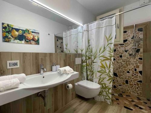 a bathroom with a sink and a toilet and a shower at Appartamento Burantinu in Alghero