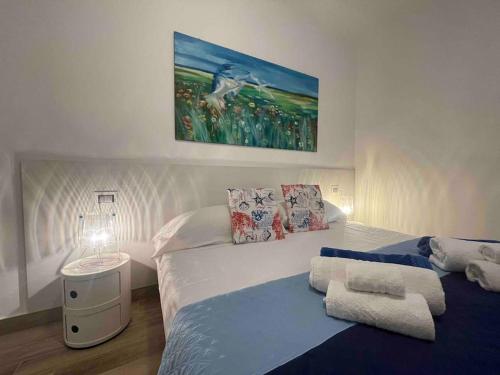 a bedroom with a bed and a painting on the wall at Appartamento Burantinu in Alghero
