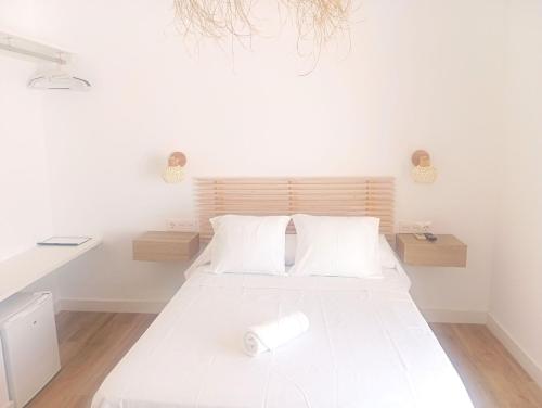 a bedroom with a large white bed with white pillows at HOSTAL CASA EMILIO in Almería