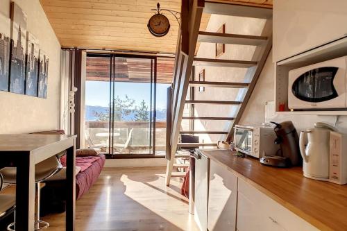 フォン・ロムー・オデイヨ・ヴィアにあるAppartement duplex et terrasse superbe vue avec garageの小さな家の中に小さなキッチン(階段付)