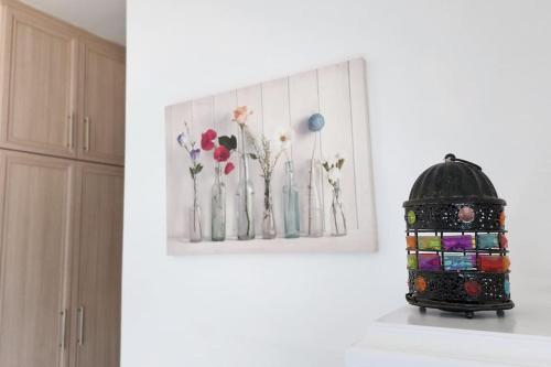 a vase on a counter with a picture of flowers at 3 bedroom bungalow in Alsancak in Kérynia