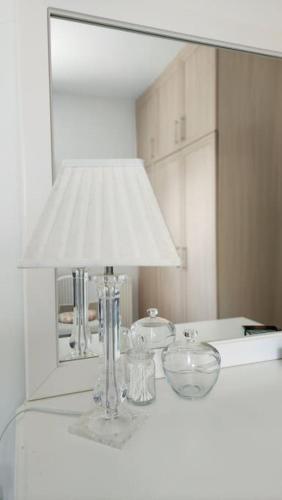 a lamp sitting on a counter with a mirror at 3 bedroom bungalow in Alsancak in Kérynia
