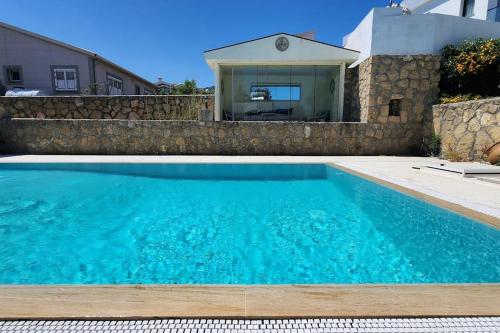 a swimming pool in front of a house at 3 bedroom bungalow in Alsancak in Kérynia