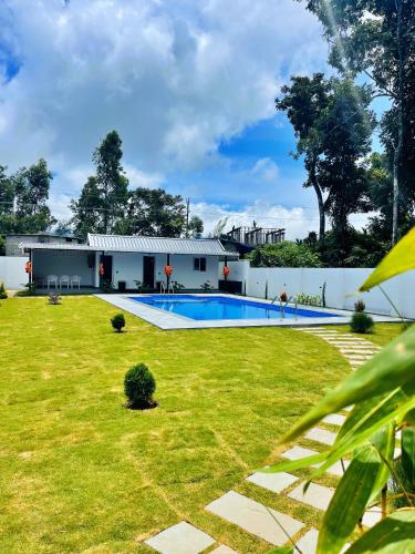 a house with a swimming pool in a yard at The Windy Mist Resort Munnar in Chinnakanal