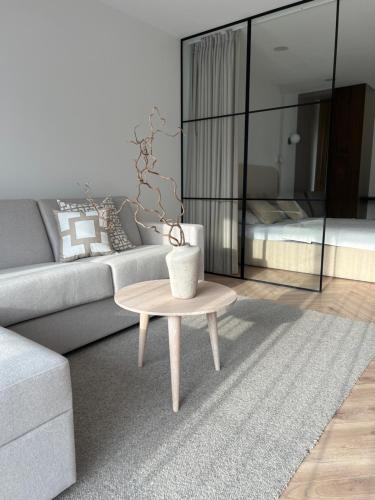 a living room with a couch and a table at Apartamentai Palangos Kopos in Palanga