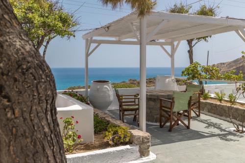 a patio with a table and chairs under a white umbrella at Summer Residence in Provatas