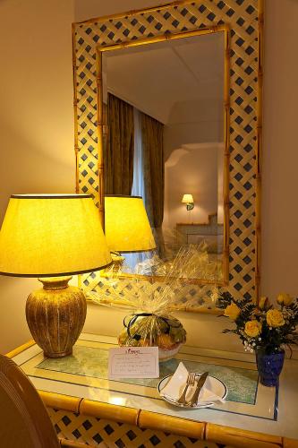 a table with two lamps and a mirror on it at Grand Hotel Il Moresco in Ischia