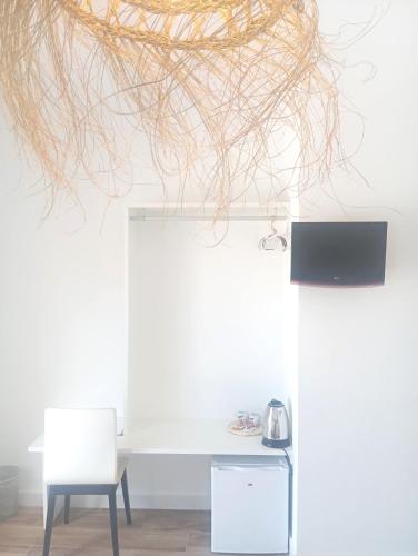 a room with two white chairs and a sculpture at HOSTAL CASA EMILIO in Almería