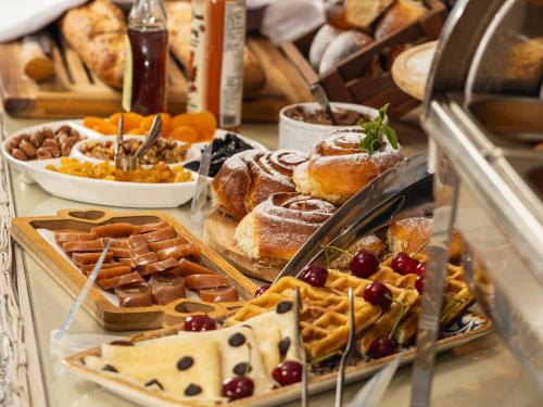 a display case with various pastries and other foods at Hotel Sapphire Bakuriani in Bakuriani
