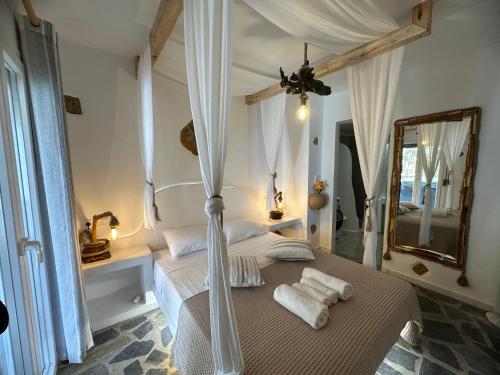 a bedroom with a canopy bed with towels on it at Janakos Luxury Apartment in Glinado Naxos