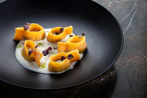 a black plate with a deviled egg on a table at Jiva Hill Resort - Genève in Crozet