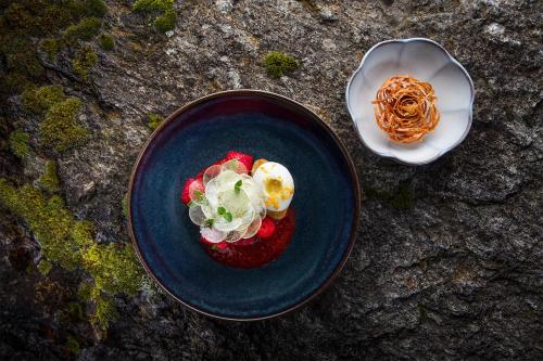 a blue plate of food with strawberries and whipped cream at Jiva Hill Resort - Genève in Crozet