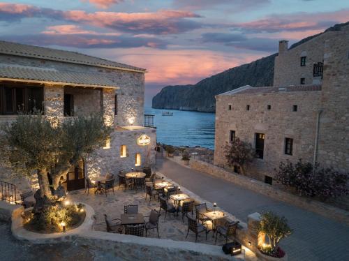 an outdoor patio with tables and chairs at night at KaSeas Boutique Hotel in Gerolimenas