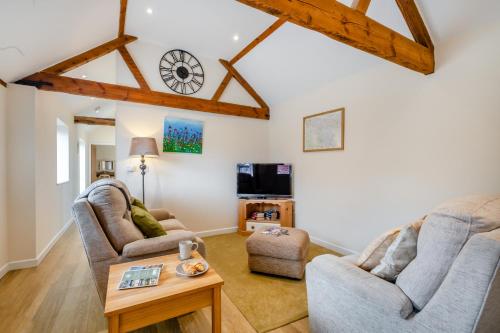 a living room with two chairs and a table at The Old Dairy & The Old Stables in Thetford