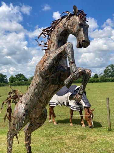 a statue of a horse with a man inspecting it at The Old Dairy & The Old Stables in Thetford