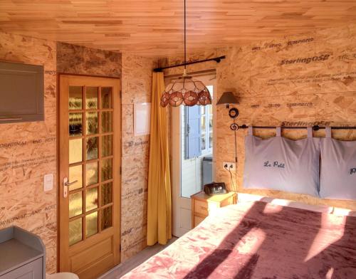 a bedroom with a bed in a stone wall at Bungalow de 2 chambres avec piscine privee jardin clos et wifi a Saint Chamassy a 3 km de la plage in Saint-Chamassy