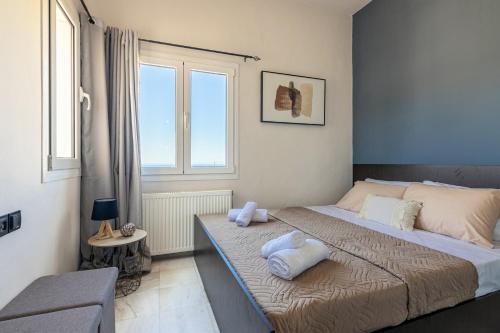 a bedroom with a bed with towels on it at Aegean Sunset Luxury Penthouse in Lygaria