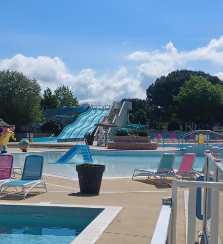 un parc aquatique avec un toboggan en arrière-plan dans l'établissement Mobil Home 710 Bora Bora 3 chambres, à Gastes