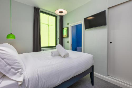 a bedroom with a white bed with two pillows on it at ART B&B in Blackpool