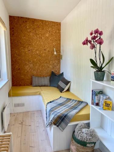a small room with a yellow bed with a plant at Whitebeam, Moor and Sea Holidays, beautiful views over Exmoor in Lynton