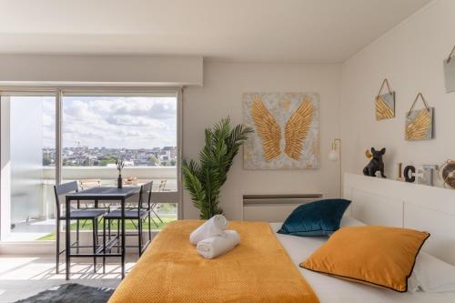 une chambre avec un lit et une salle à manger avec une table dans l'établissement Le Studio de l'Ange - Vue imprenable, à Rennes