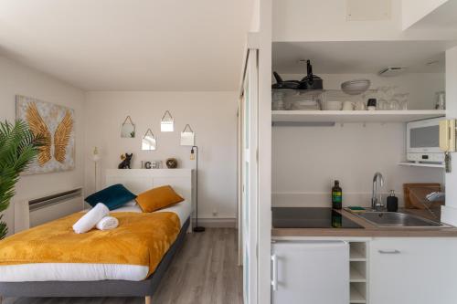 une petite chambre avec un lit et une cuisine dans l'établissement Le Studio de l'Ange - Vue imprenable, à Rennes