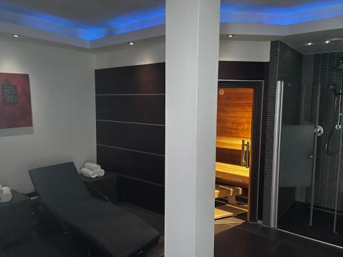 a room with a shower with a chair and a desk at Central Hotel in Villingen-Schwenningen
