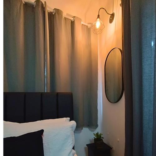 a bedroom with a bed with a black headboard and a mirror at Apêzinho Vidigal - RJ in Rio de Janeiro