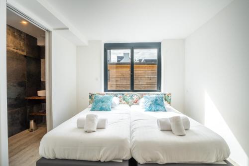 deux lits dans une chambre avec une fenêtre dans l'établissement Captain Kerino - Duplex vue mer, à Vannes