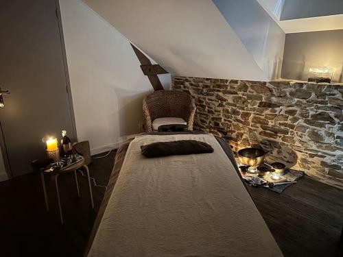 une chambre avec un lit et un mur en pierre dans l'établissement Eco Gîte 12 pers La Charmante des Vallons avec SPA, à Saint-Mars-la-Jaille