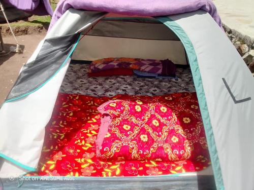 an open tent with a red blanket in it at Kedar Tent House in Kedārnāth