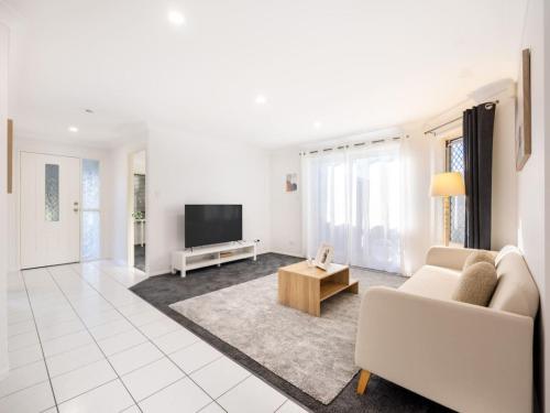 a living room with a couch and a tv at Private and Spacious 4BR Home with Parkview 5mins to Mall in Doolandella