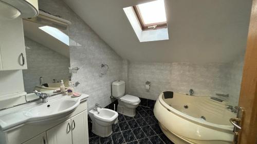 a bathroom with a sink and a toilet and a tub at D&S Apartment Ohrid in Ohrid