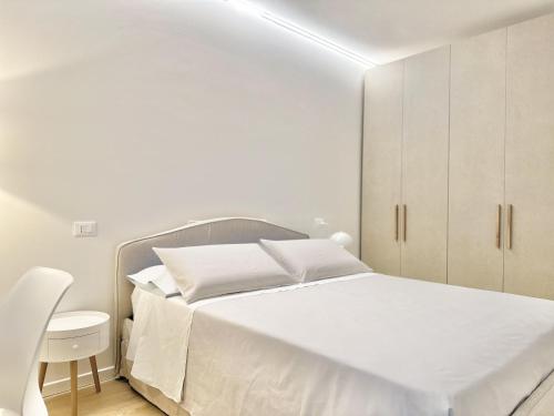 a white bedroom with a bed and a white cabinet at House of Art in Arezzo