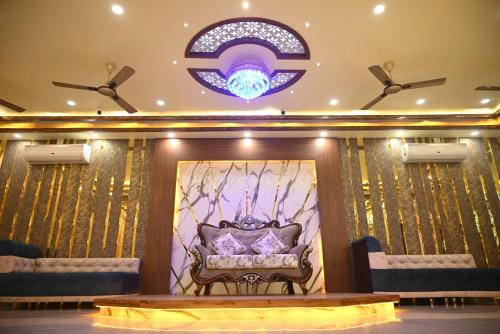 a stage with a couch in a room with a ceiling at PS Luxury Hotel in Baharampur