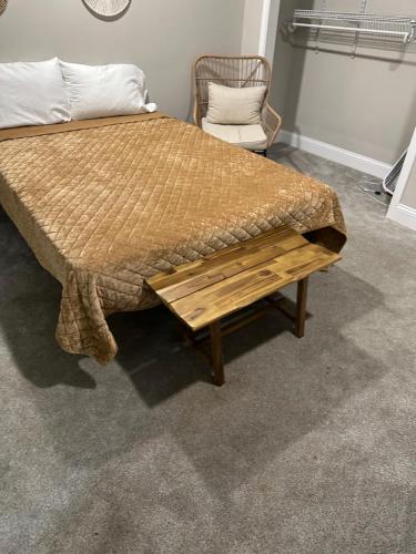 a bed with a wooden foot board and a chair at Serenity away from the big city in Amelia