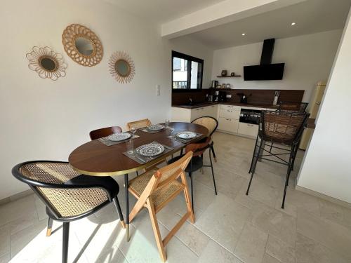 une cuisine et une salle à manger avec une table et des chaises en bois dans l'établissement Les mouettes, SPA privé, 600m de la plage, Formule tout inclus, à Erdeven