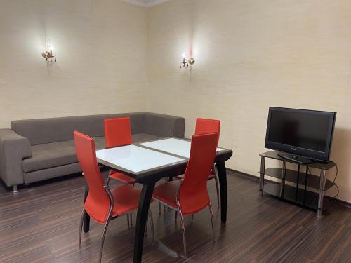 a dining room with a table and red chairs at Valencia Hotel in Odesa