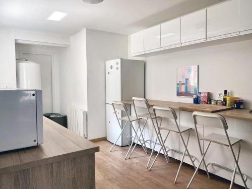 Il comprend une cuisine équipée d'un comptoir avec des chaises et d'un réfrigérateur. dans l'établissement Maison de ville moderne en plein cœur de Rouen, à Rouen